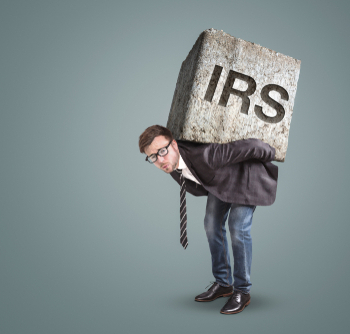 Businessman,Bending,Under,A,Heavy,Stone,With,The,Letters,Irs